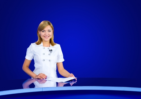 a television anchorwoman at an empty blue studioの写真素材