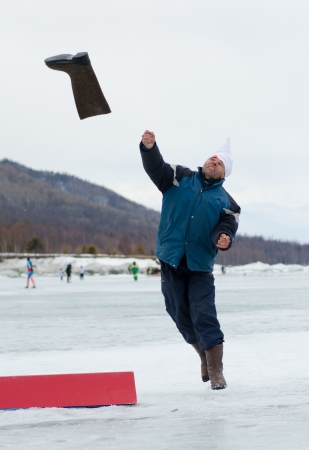 YARTSI, RUSSIA - APRIL 14  At annual Baikal Fishing Valenok Throwing was run, Apr 14, 2012, Yartsi, Buryatia, Russia  An unidentified man makes his throw のeditorial素材