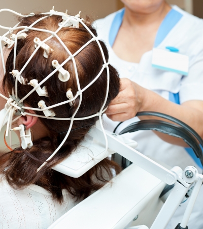 rheoencephalography - a doctor attaches electrodes on a patients headの写真素材