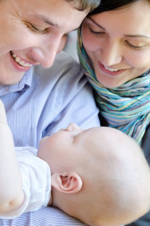young Caucasian man and woman hold their babyの写真素材
