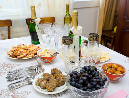 some festive cold snacks and bottles of champagne on tableの写真素材