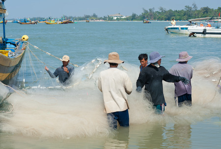 PHAN THIET, VIETNAM - MARCH 6, 2013  Unidentified local fishers take their catch and untwine the net after the night fishing のeditorial素材