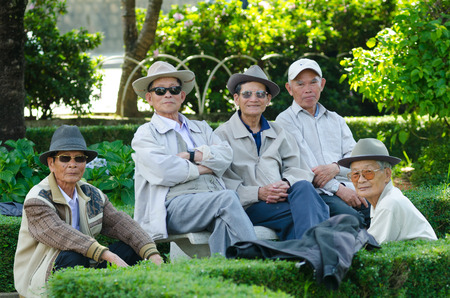 DALAT, VIETNAM - JUNE 8, 2014: A group of unidentified Vietnamese senior men having a rest in a park pose for camera. The park near the city market is favoured by townspeople.のeditorial素材