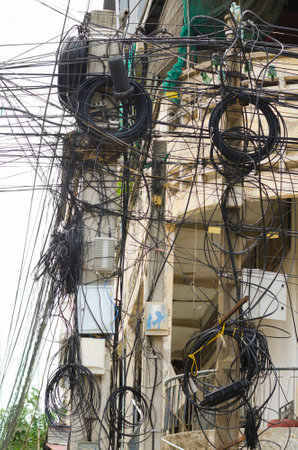 tangled wires on electric poles in Cambodiaの写真素材