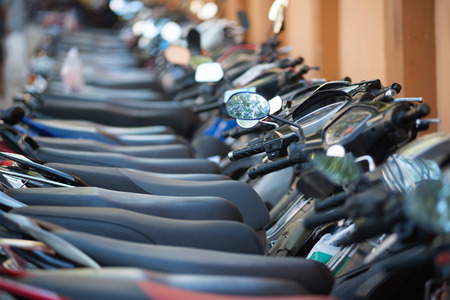 many motorcycles in a line at a downtown parking lotの写真素材