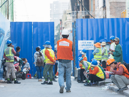 HO CHI MINH, VIETNAM - JAN 15, 2015: Unidentified workers wait for their working day near a gate. The construction of Metro Line 1 began in August 2012, and opening day will be in 2018.のeditorial素材