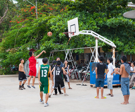 NHA TRANG, VIETNAM - AUG 5, 2014: Unidentified teenagers play basketball in a yard in the downtown. The city is a very popular fast developing sea resort.のeditorial素材