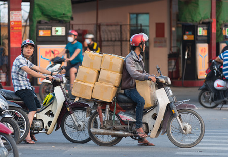 HOCHIMINH, VIETNAM - APRIL 19, 2015: An unidentified motorcyclist drives several boxes in Truong Chinh Street during rush hours. The main means of cargo transportation in Vietnam is motorcycle.のeditorial素材