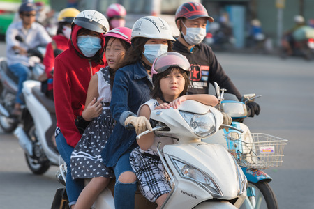 HOCHIMINH, VIETNAM - APRIL 19, 2015: An unidentified woman motorcyclist drives three passengers in Truong Chinh Street during rush hours. The main means of transportation in Vietnam is motorcycle.のeditorial素材