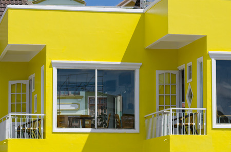 bright yellow painted house with tiny balconiesの写真素材