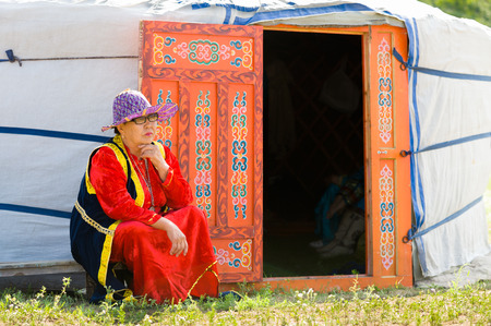 ULAN-UDE, RUSSIA - JULY 17, 2010: A Buryat woman sits by a yurt during the 4th General Session of the World Mongolians Convention. People from Russia,  Mongolia and China attended the meeting.のeditorial素材