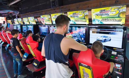 BANGKOK - MARCH 16, 2016: Unidentified young men and teenagers play on game machines at the Hero city at the MBK Center, a shopping mall. Bangkok is one of the worlds top tourist destination cities.のeditorial素材
