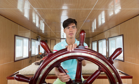 HA LONG, VIETNAM - AUGUST 13, 2016: An unidentified navigator steers boat Truong Giang 68 in Ha Long Bay, a UNESCO World Heritage Site and popular travel destination in Quang Ninh Province.のeditorial素材