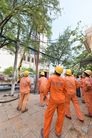 CAN THO, VIETNAM - MAY 17, 2016: Unidentified workers of the local branch of VietNam Electricity work in the street. It is the largest power company in Vietnam.のeditorial素材