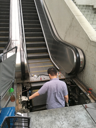 service technician does maintenance work for escalatorの写真素材