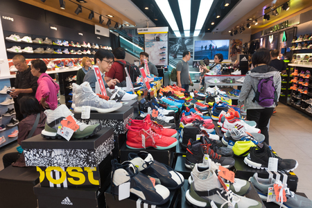 HONG KONG - MARCH 20, 2017: People buy shoes at an Adidas store in Tsim Sha Tsui. Adidas AG is a German corporation, the largest sportswear manufacturer in Europe and the second biggest in the world.のeditorial素材