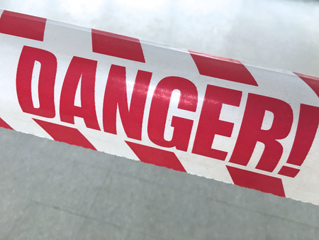 danger red letters on a white tape