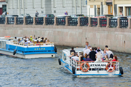 ST PETERSBURG - JUNE 30, 2011: Four river buses wait for mooring at the Moyka Embankment after tour. River tours are very popular as there are about 100 rivers and channels in the city.のeditorial素材