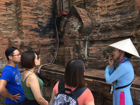 NHA TRANG, VIETNAM - OCTOBER 2017: An unidentified Vietnamese woman conducts a guided tour for a group of tourists at Ponagar Cham temple tower of the 8th century.のeditorial素材