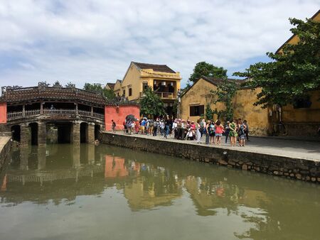 HOI AN, VIETNAM - OCTOBER 2017: Tourists by the Bridge Pagoda or Japanese Bridge built in the 17th...