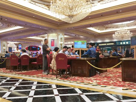 MACAU - SEPT 2017: Unidentified people play at a gaming hall of Parisian casino. Macauâs gaming revenue has been the worlds largest since 2006 with the economy heavily dependent on gaming and tourismのeditorial素材
