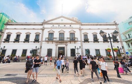 MACAU - SEPTEMBER 16, 2017: People stroll by the Civic and Municipal Affairs Bureau (Portuguese:...