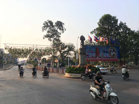 SIEM REAP, CAMBODIA - APRIL 8, 2020: Unidentified motorbike drivers move round Apsara Statue Circle.のeditorial素材