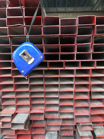 many rectangular metal profiles on sale at a shop with a tape lineの写真素材