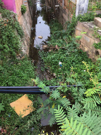 a drain ditch between houses in Cambodiaの写真素材