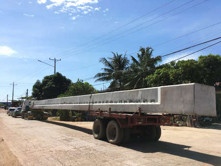 KAMPOT, CAMBODIA - DECEMBER 12, 2021: A truck drives a metal concrete part of a new bridge under construction.のeditorial素材
