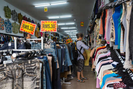 KUALA LUMPUR - MARCH 14, 2017: Asian women buy clothes at a second hand store in Chinatown, known as Petaling street.のeditorial素材