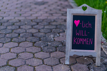 Welcome board on walkway in front of green lawnの写真素材