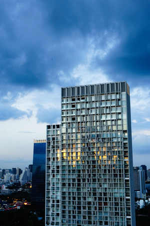 skyscraper reflecting sunset in a stormy cloudのeditorial素材