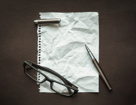 Torn paper from a notebook with wrinkle texture on a luxury leather surfaceの写真素材