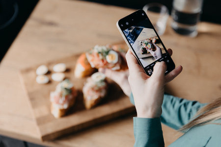 A pretty young woman shooting a blog about cooking. Video Blog About Healthy Food. Attractive Woman is talking and Cooking on the telephone.の写真素材