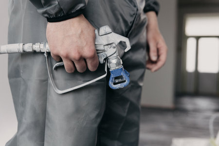 A painters arm and an Industrial size airless spray gun used for industrial painting and coating. Shot on white background.の写真素材