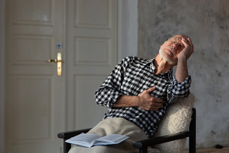 Senior male suffering from bad pain in his chest heart attack at home.の写真素材