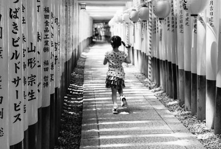 Unidentified girl running through tunnel of poles at Fushimi Inari Shrineのeditorial素材