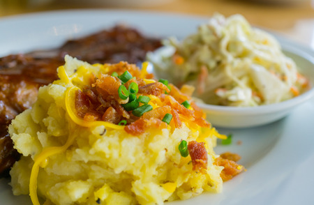 Mashed potatoes with leeks and crispy bacon in a plateの写真素材