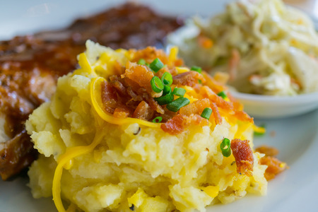 Mashed potatoes with leeks and crispy bacon in a plateの写真素材
