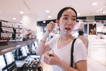 Woman trying earring at the shopの写真素材