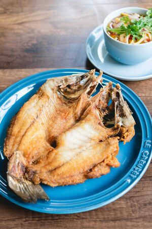 Deep fried sea bass on wooden table