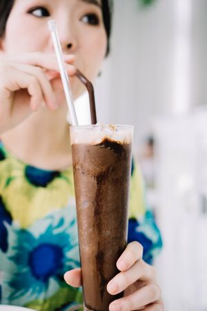 Woman sipping iced chocolate frappe