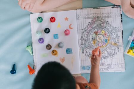 Little boy toddler play with color and coloring in the bookの写真素材