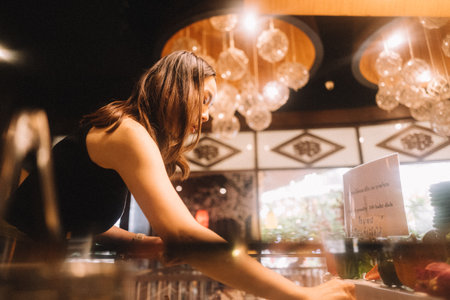 Asian woman picking food at restaurantの写真素材