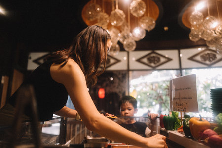 Asian woman serving food in a coffee shop or restaurant.の写真素材