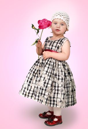      Little girl with peony on pink background     の写真素材