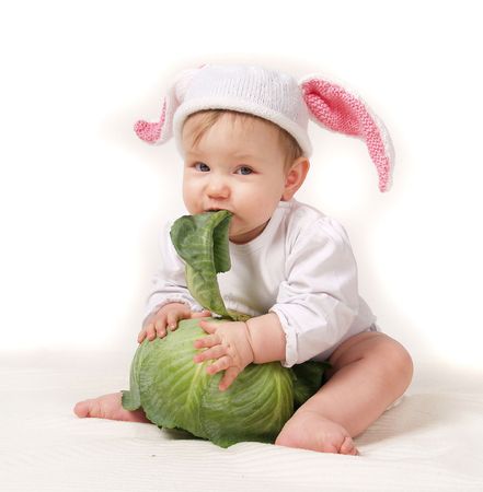 Baby, sitting baby in a hat with cabbage. の写真素材