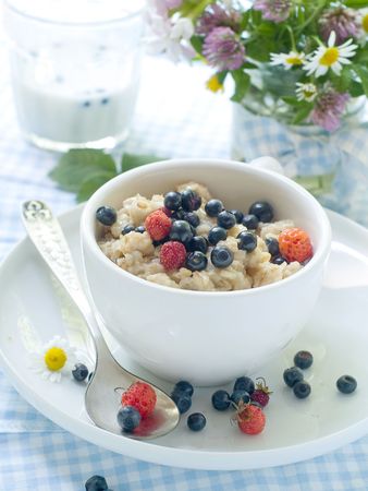 Porridge with blueberries and strawberries for breakfastの写真素材