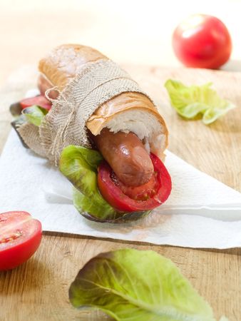 Sausages in  baguette with fresh tomato and lettuceの写真素材